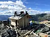 Dugnadslag arbeider på sikringsbu på fjellet.