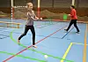 Jente slår ein innebandy-ball.